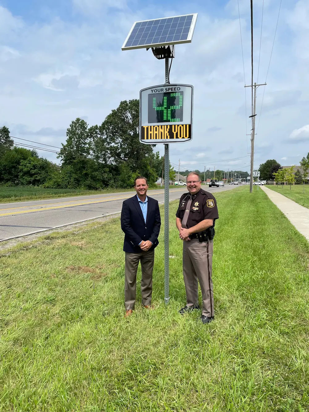 A major and a sheriff in front a EVOLIS radar speed sign installed in a city in the US A major and a sheriff in front a EVOLIS radar speed sign installed in a city in the US